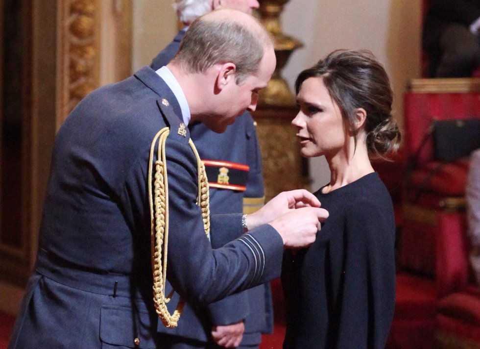 Victoria Beckham receives her OBE from the Duke of Cambridge during an investitu