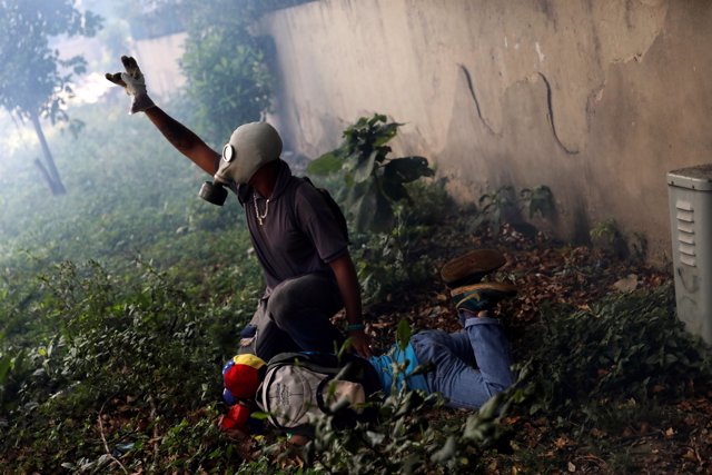 An injured demonstrators is been helped by another protester after clashing with