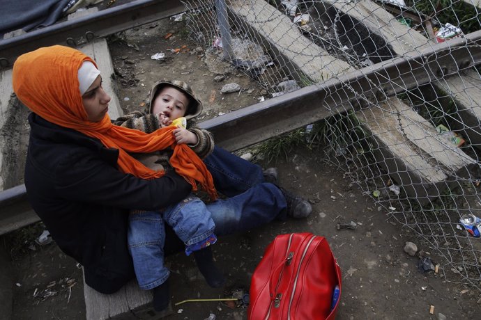 Una inmigrante y su hijo esperan en Idomeni (Grecia) a cruzar a Macedonia