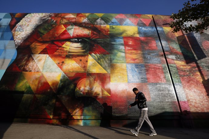 A man walks past a mural of Nelson Mandela painted by Brazilian artist Eduardo K