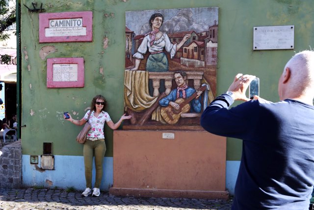 A tourist poses at Caminito, a tourist hotspot of La Boca neighborhood in Buenos