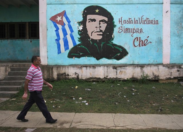 Un hombre pasea por La Habana frente a un mural del Che