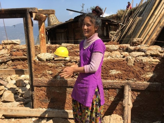 Mujer ayuda en la reconstrucción de su casa en Nepal
