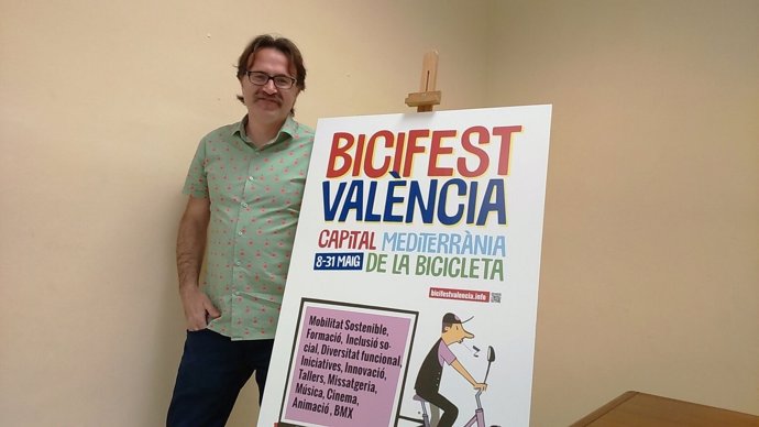 El concejal Giuseppe grezzi con el cartel anunciador del Bicifest