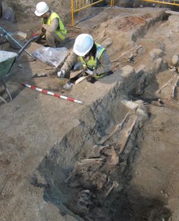 Dos arqueólogos trabajan con restos óseos aparecidos en Iglesia de la Magdalena