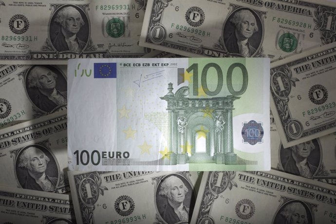 A picture illustration shows a 100 euro banknote laying on one Dollar banknotes,