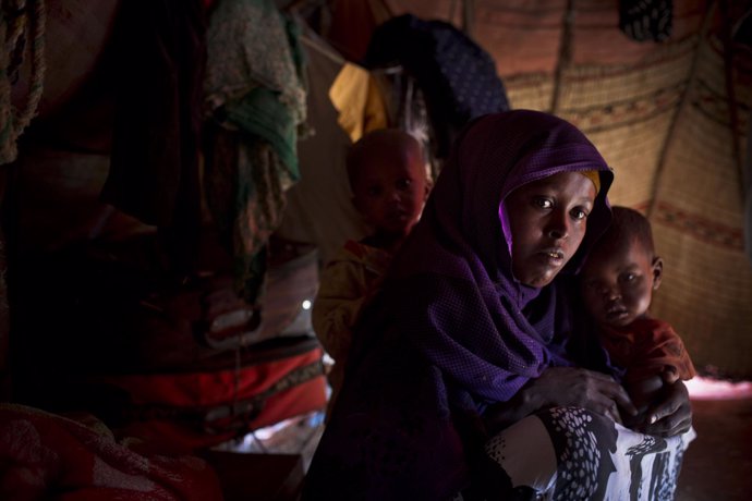 Una madre somalí junto con sus dos hijos enfermos