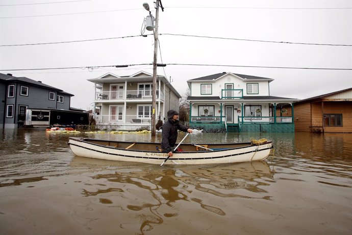 A man paddles a canoe in a flooded residential area in Gatineau, Quebec, Canada,