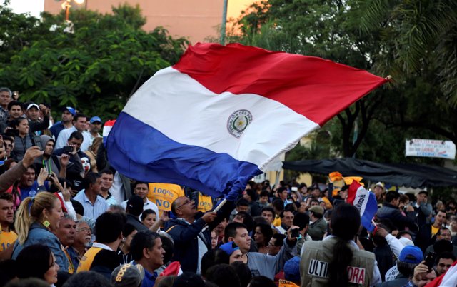 People wave a Paraguayan flag to celebrate the rejection of a proposed amendment