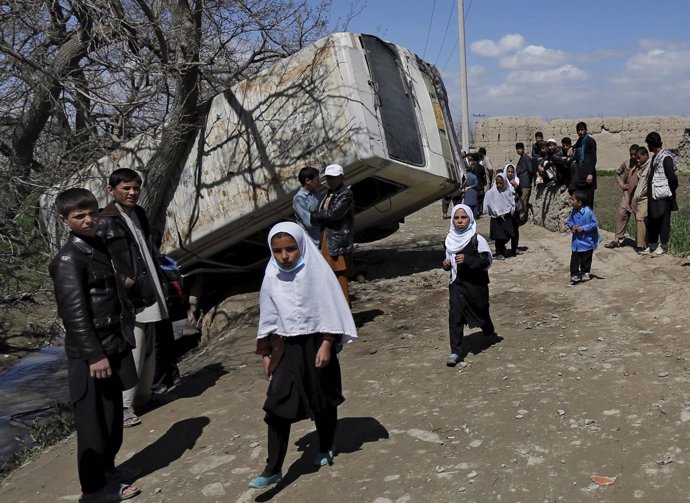 Niñas junto a un autobús dañado por una explosión en Kabul