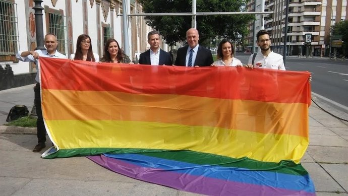 Autoridades posan con la bandera arco iris antes de su izado