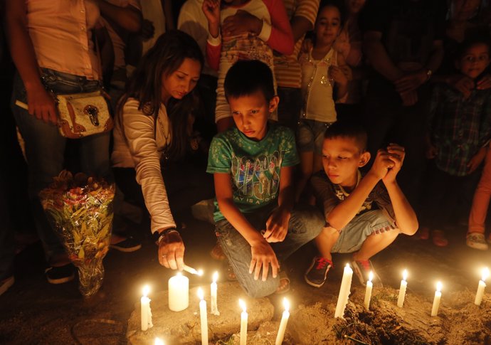 Relatives and residents light candles, in memory of the children who died in a b