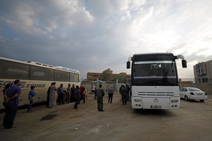 Passengers wait in Qamishli city in Syria's Kurdish-held northeast to embark on 