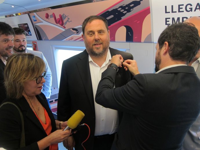 Un col·laborador col·loca al vpte.O.Junqueras la insígnia de conseller