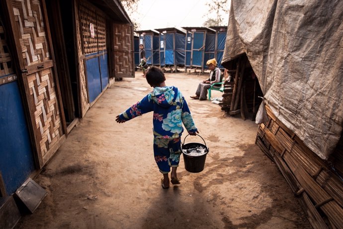 Un niño birmano recogiendo agua para su familia