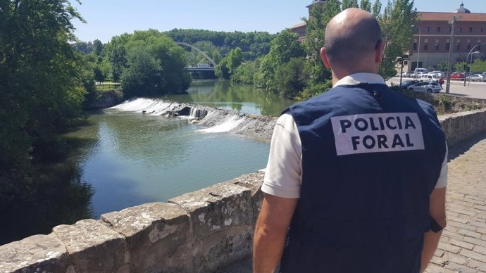 Agente de la Policía Foral junto al río Arga.