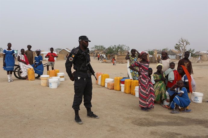Un policía camerunés junto a refugiados nigerianos en Minawao