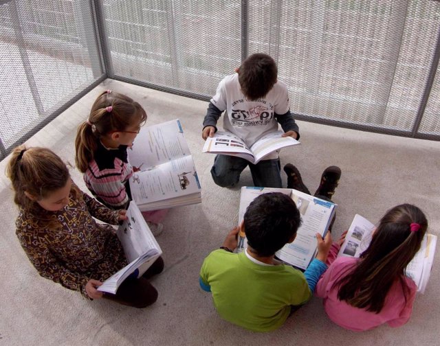 Alumnos leen sus libros de texto