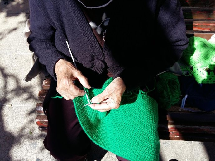 Una mujer teje una manta para visibilizar la Miastenia
