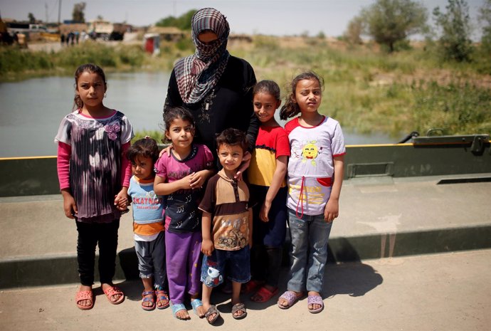 Una mujer iraquí con sus hijos tras huir de Mosul