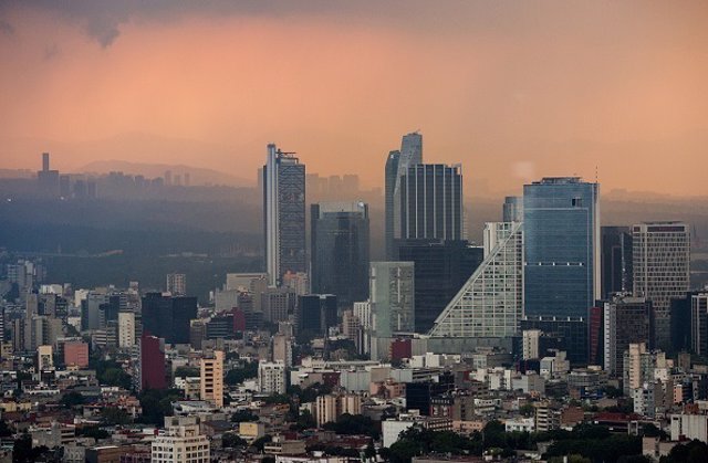 Smog hangs at dusk over downtown Mexico City, Mexico, on Thursday, Aug. 11, 2016