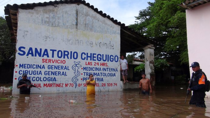 Policemen patrol a street flooded by the rains of Tropical Storm Beatriz in Juch