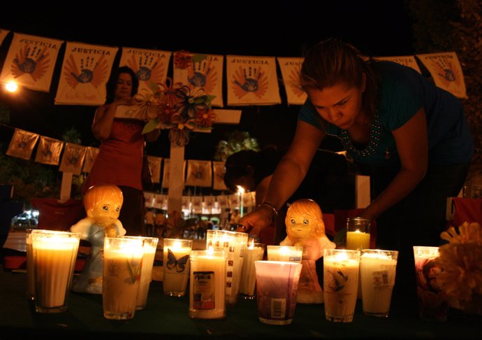 A woman takes part in a candlelight vigil for the victims of a fire at a day-car