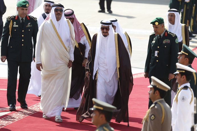 El rey saudí Salman bin Abdulaziz camina con el emir de Qatar Tamim bin Hamad.