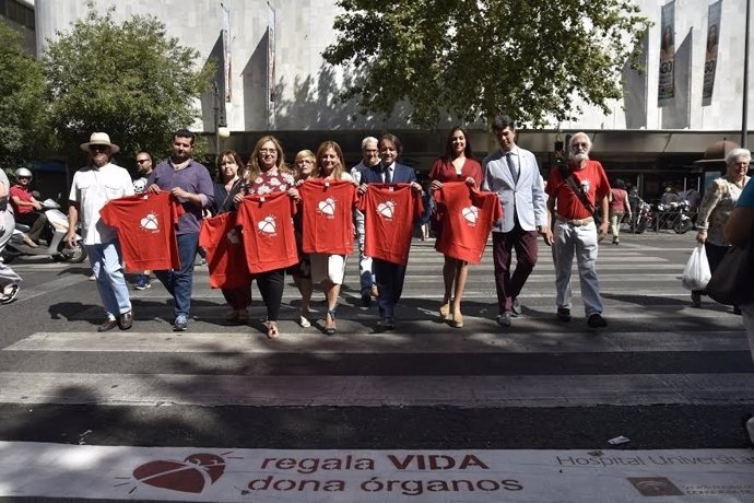 Autoridades sanitarias cruzan un paso de peatones con el lema de la campaña