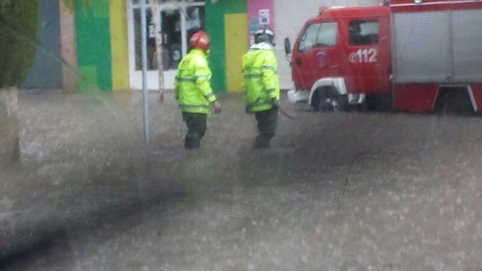 Bomberos en la calle, lluvias y tormenta