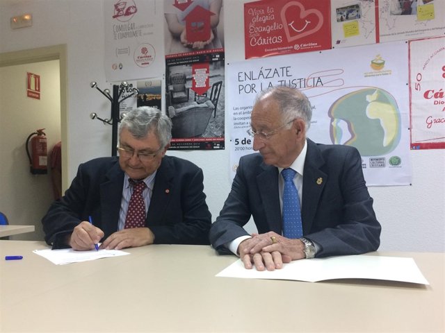 Gabriel Amat junto al director de Cáritas, firmando la ayuda de 6.000 euros.