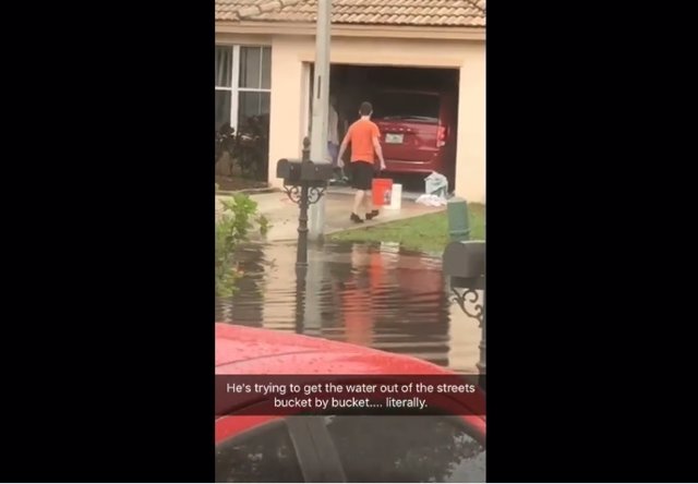 Un hombre intenta acabar con una inundación cubo a cubo