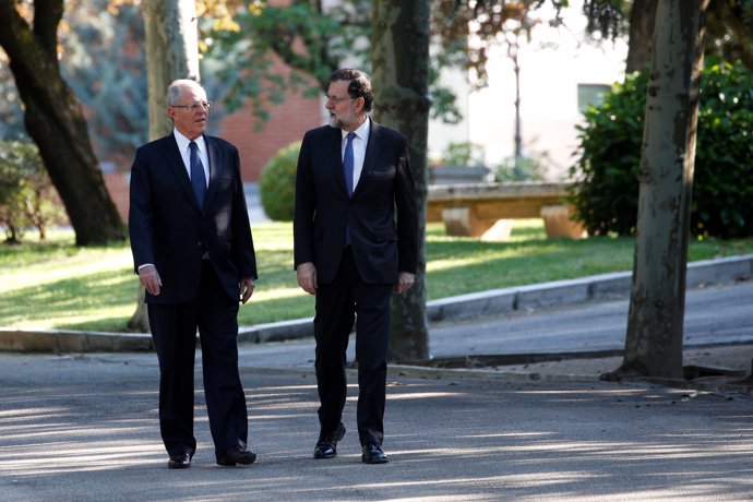 Spanish Prime Minister Mariano Rajoy (R) walks with Peru's President Pedro Pablo