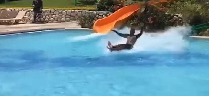Este hombre se desliza por el agua tras tirarse de un tobogán acuático