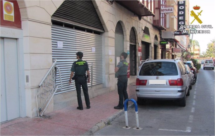 Dos agentes ante el local donde supuestamente sucedieron los hechos