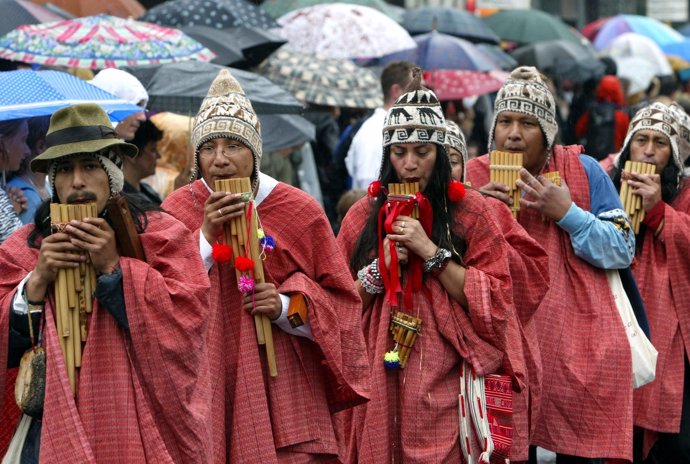 Peruvian panpipes player perform in the rain during a street carnival of Berlin'