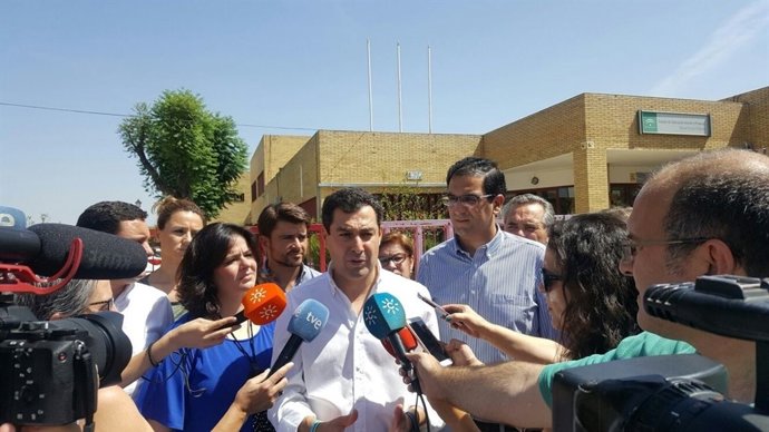 Juanma Moreno atiende a los medios tras abordar la climatización con el AMPA