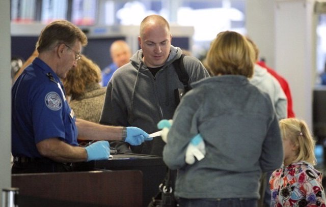 A U.S. Transportation Security Administration agent checks travel tickets at a s