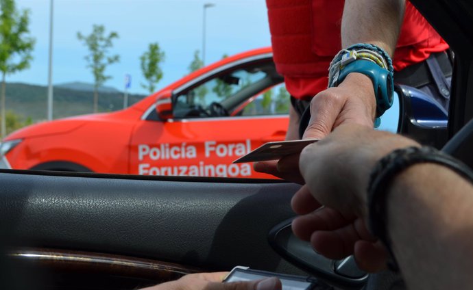 Un conductor entrega su documentación a un policía foral