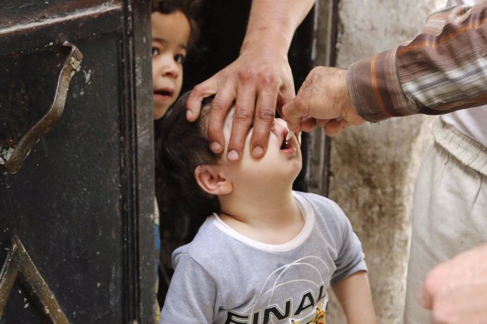 Un niño toma la vacuna contra la polio en Alepo, Siria. 
