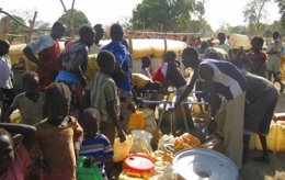 Homes del Sudan esperant per omplir les seves garrafes