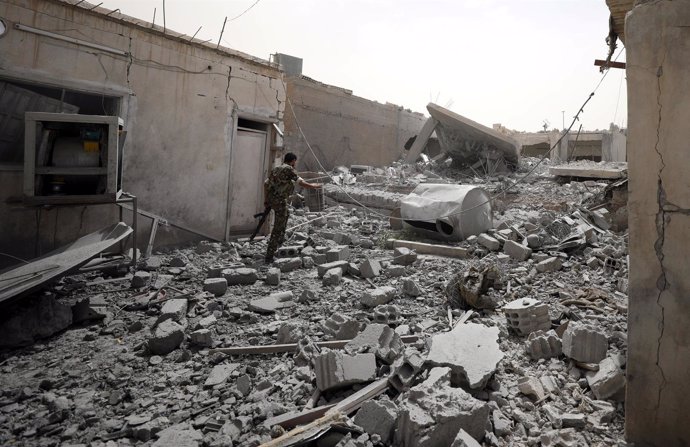 Un rebelde sirio camina entre los escombros en Raqqa