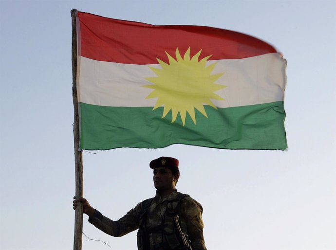 Un soldado peshmerga con una bandera del Kurdistán