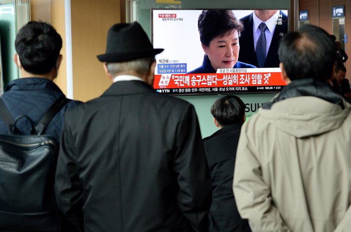 Personas ante un televisor con la imagen de Park Geun Hye