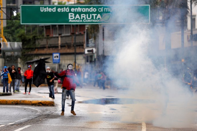 Demonstrators clash with riot security forces while rallying against Venezuela's