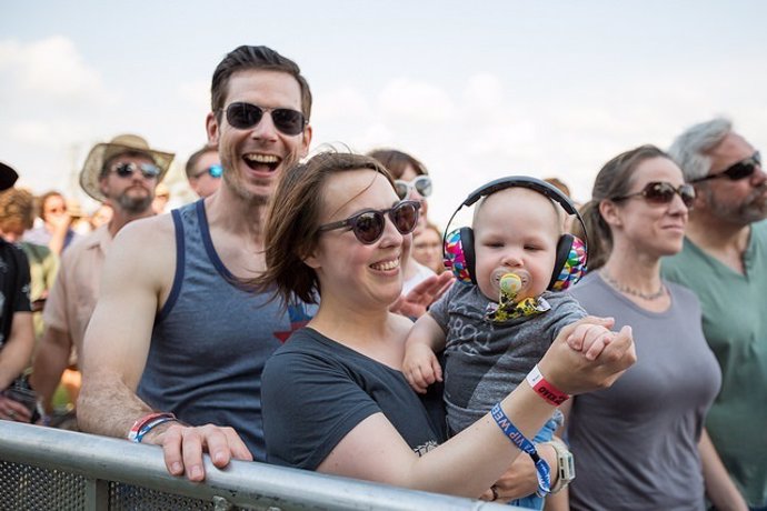 Bebé con auriculares en un concierto, familia, sonrisas