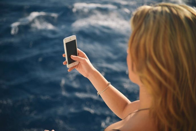 Menor usando smartphone en vacaciones