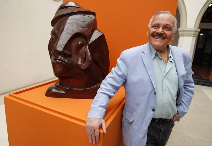 Mexican drawer, engraver and sculptor Jose Luis Cuevas poses next to a bronze sc