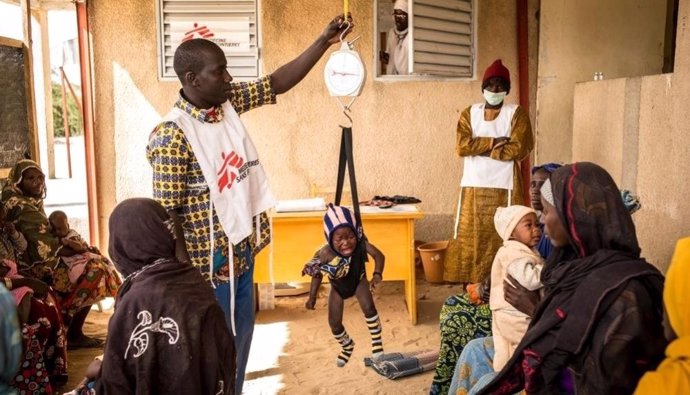 Médico tomando el peso a un niño en Níger