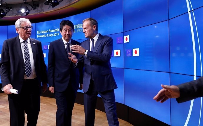 Japan's Prime Minister Shinzo Abe (C) talks with European Commission President J